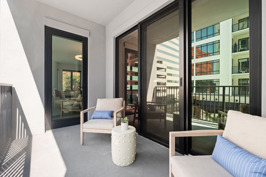 A modern living room with a chair, ottoman, and a couch.