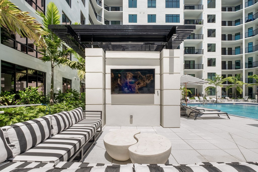 A white and black striped seating area with a television on a stand.