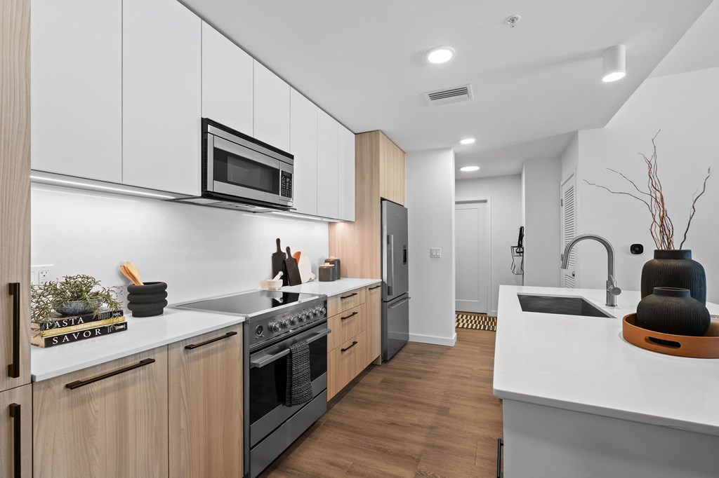 A modern kitchen with wooden cabinets and stainless steel appliances.