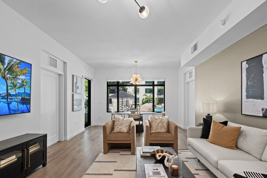 A modern living room with a large flat screen TV mounted on the wall.