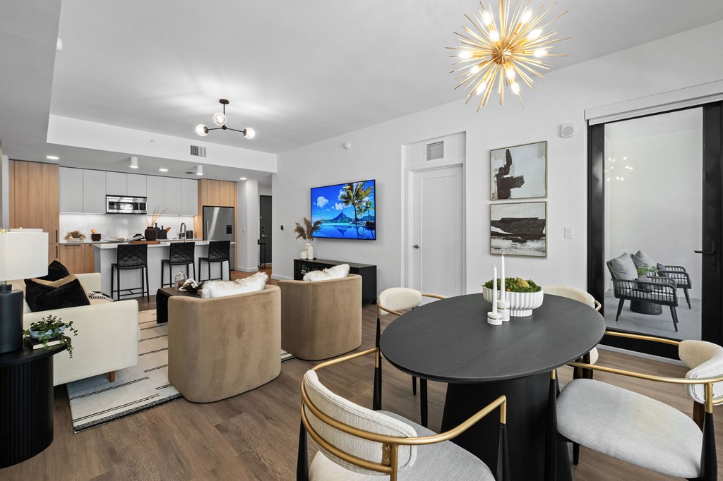 A modern living room with a black table and gold chairs.