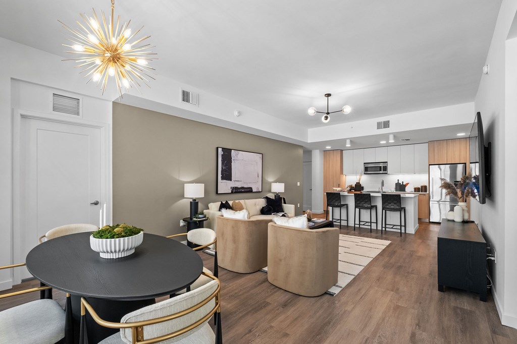 A modern living room with a black table and gold chairs.
