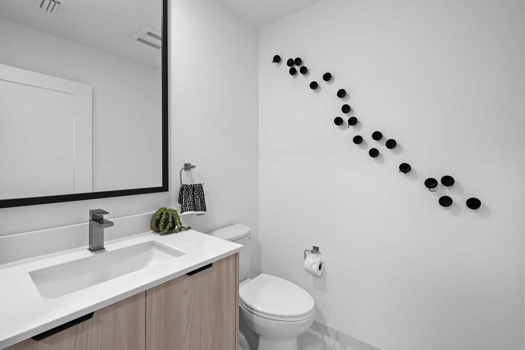 A bathroom with a white sink and toilet.