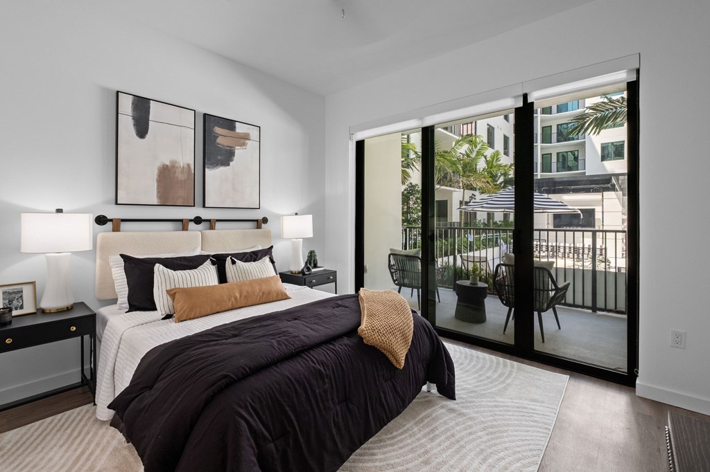 A bedroom with a large bed and a view of the outside.
