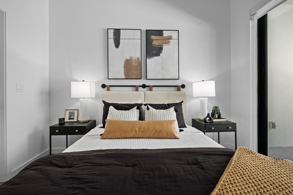 A bedroom with a large bed and two nightstands.