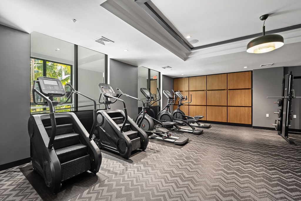 A gym with treadmills, elliptical machines, and other exercise equipment.