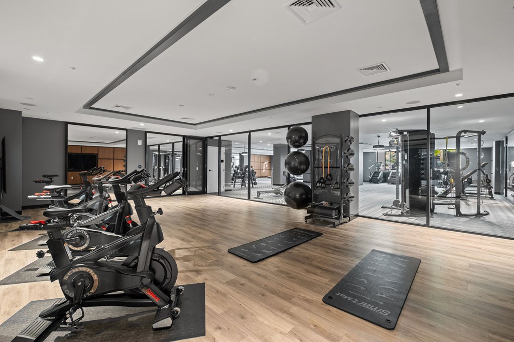 A gym with a variety of equipment including treadmills, weights, and exercise machines.