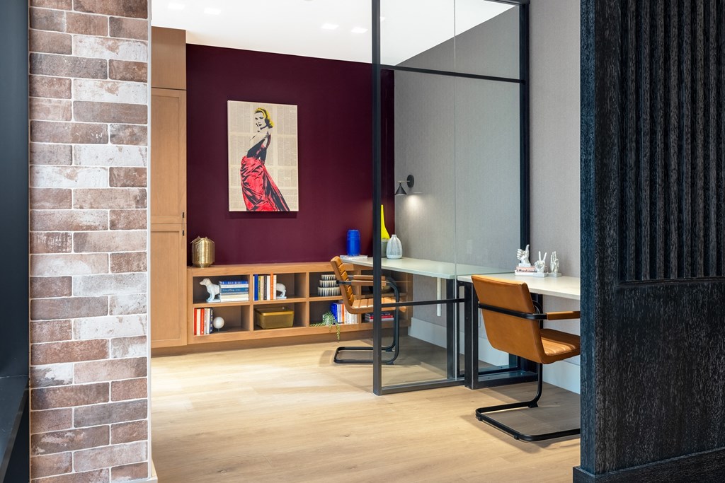 a conference room with a glass desk and a red wall