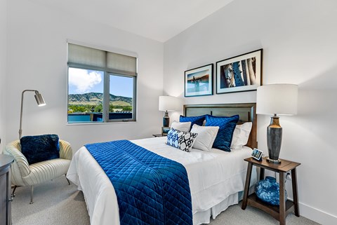 A bedroom with a large bed and a chair.