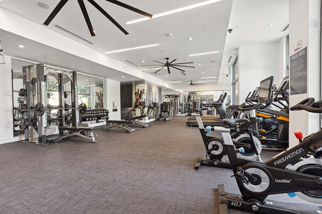 a spacious fitness center with cardio machines and other exercise equipment