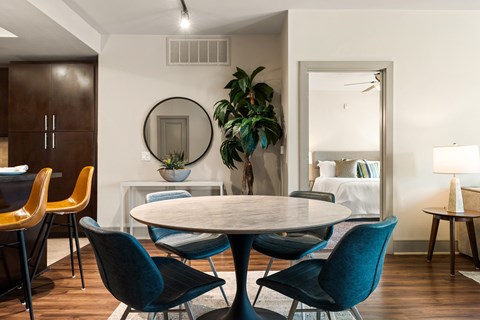 A dining room with a round table and chairs.