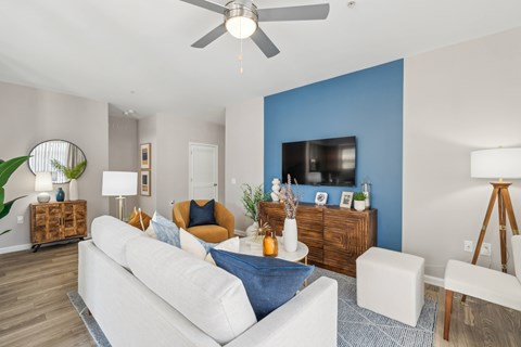 A living room with a white couch and a blue accent wall.