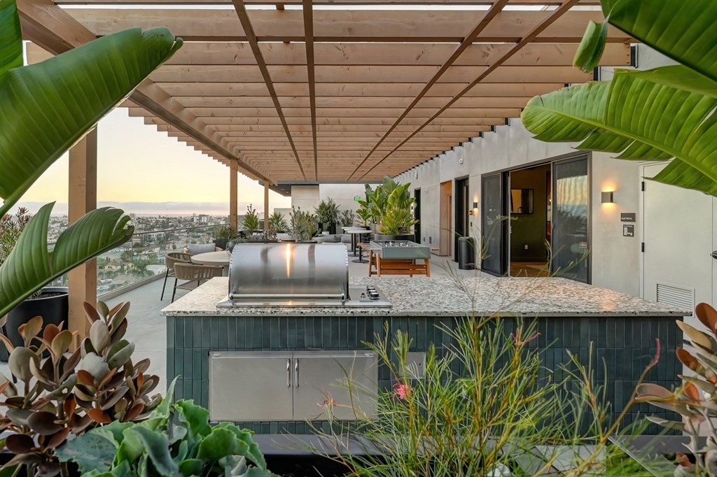 an outdoor kitchen with a bar and plants