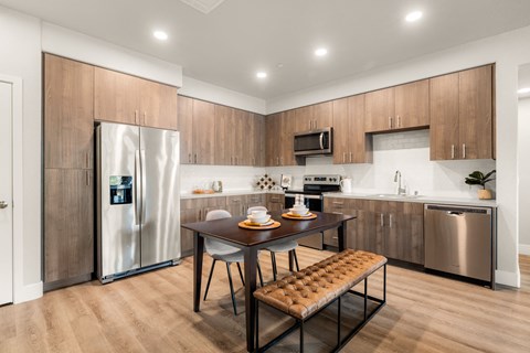 a kitchen with stainless steel appliances and a wooden table