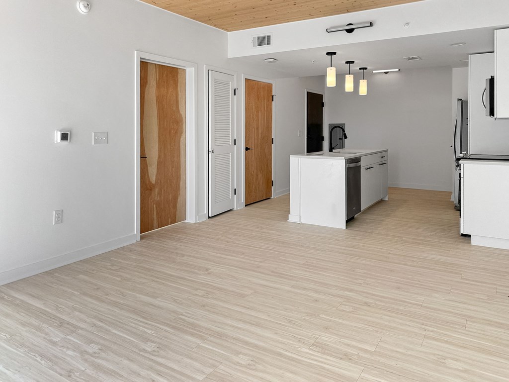 an empty kitchen and living room with a wood floor