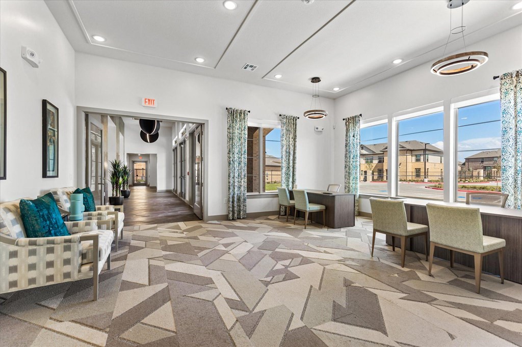 a resident clubhouse with couches and chairs and large windows