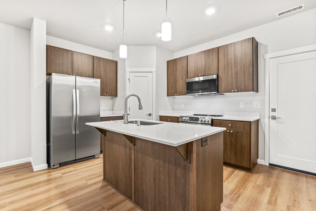 a kitchen with wooden cabinets and a stainless steel refrigerator