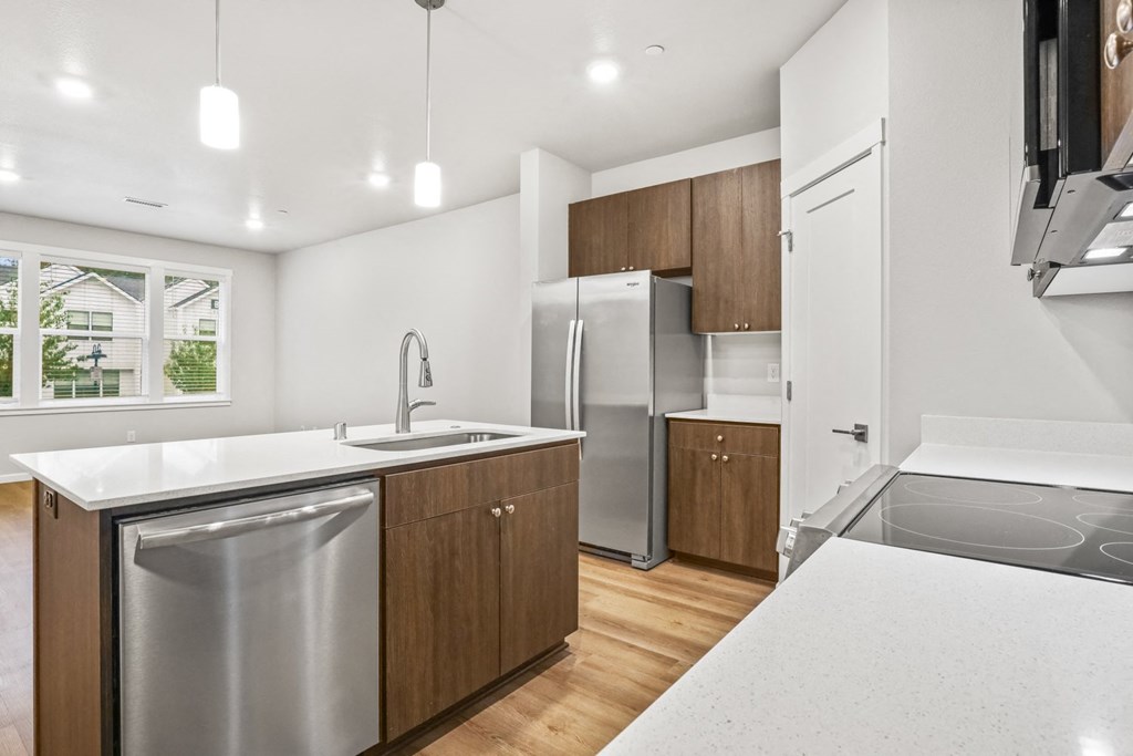 a kitchen with an island and a stainless steel refrigerator