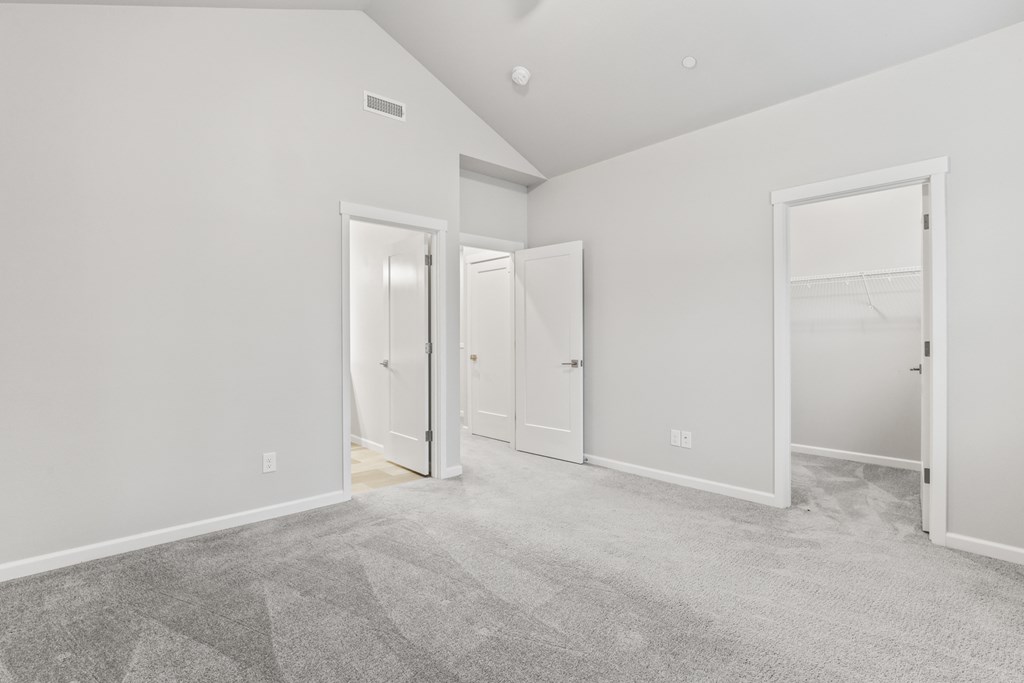 the living room of a new home with white walls and carpet