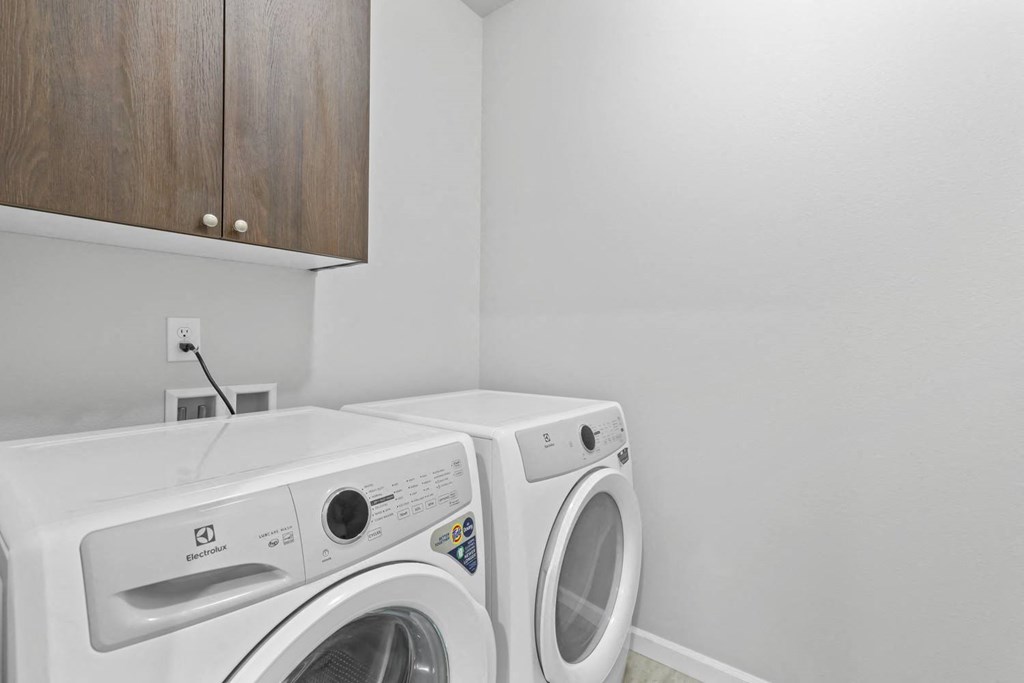a white washer and dryer in a white laundry room