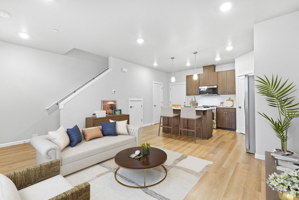 a living room with a couch and a coffee table in front of a kitchen