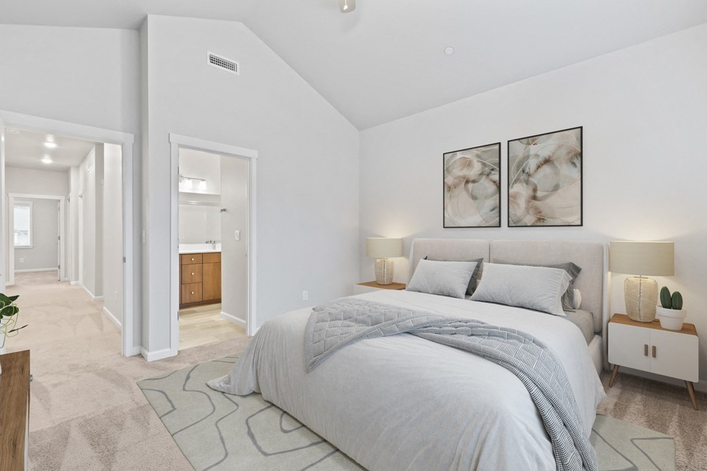 a bedroom with a bed and two paintings on the wall