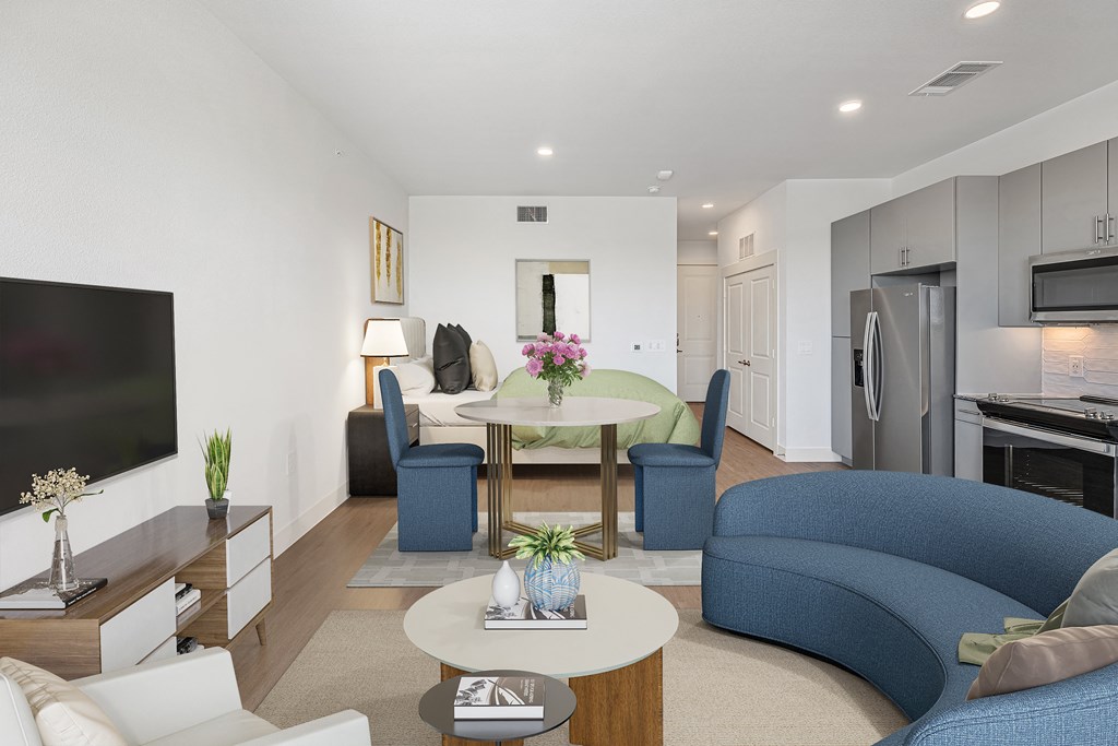 a living room with blue couches and chairs and a table