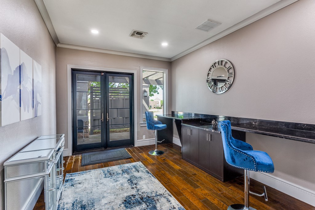 a home office with a desk and a door to a patio