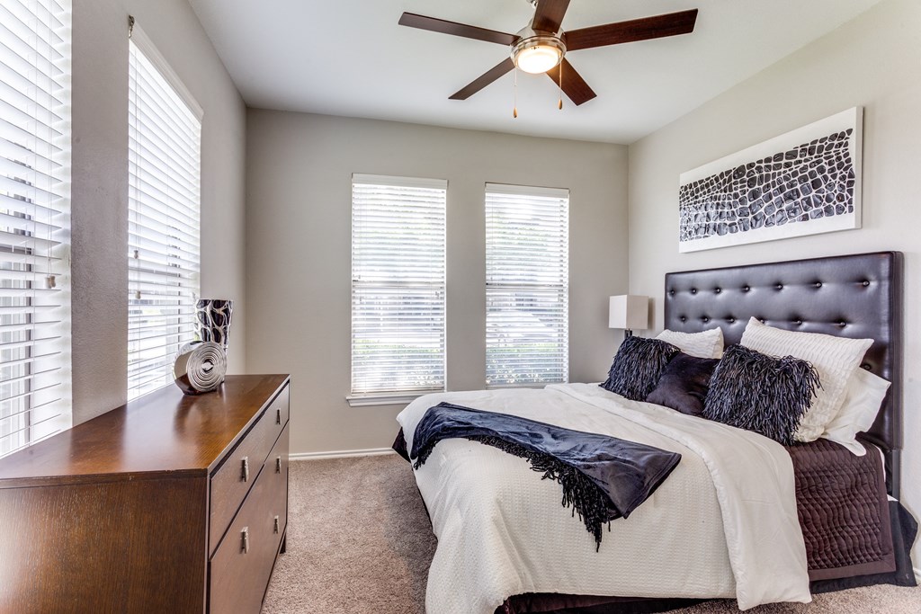 a bedroom with a large bed and a ceiling fan