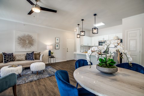 A dining room with a round table and blue chairs.