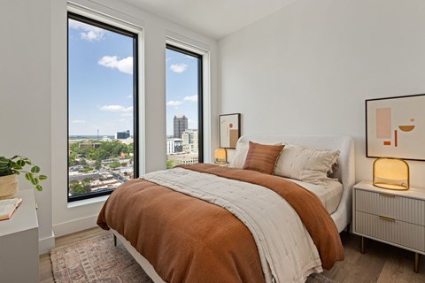 A bedroom with a large bed and a view of the city.