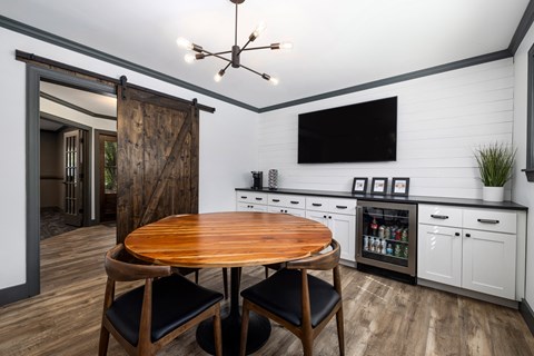 A modern kitchen with a wooden table and chairs.