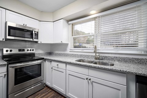A modern kitchen with a stainless steel oven and microwave.