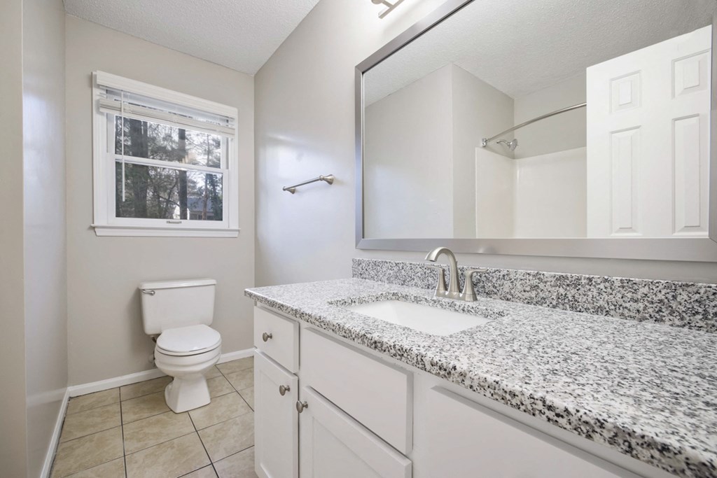 Bathroom with granite counter tops and bath tub