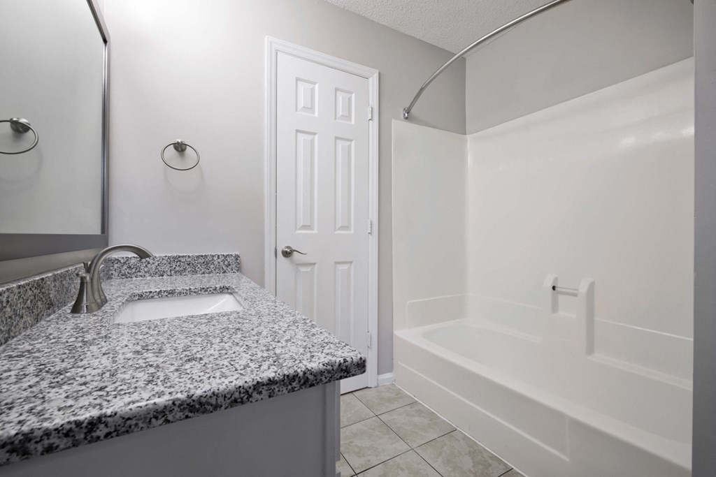 Bathroom with granite counter tops and bath tub