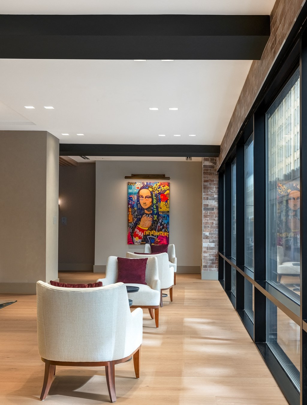 a long corridor with chairs and a painting on the wall