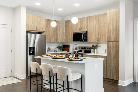 A kitchen with a white counter and bar stools.