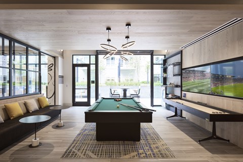 A room with a pool table and a television.