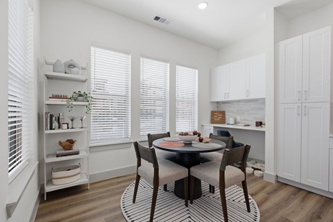A dining room with a table and chairs.