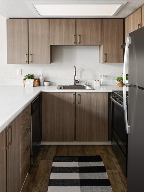 a kitchen with wooden cabinets and a sink and a refrigerator