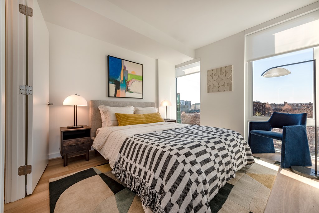 A bedroom with a large bed and a view of the city.