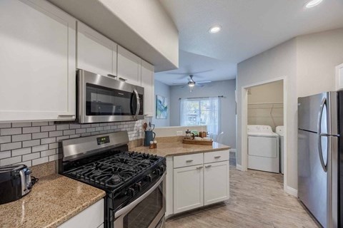 A kitchen with a black stove top oven and white cabinets.