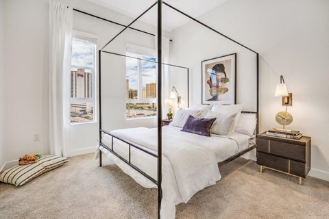 a bedroom with a large bed and two windows