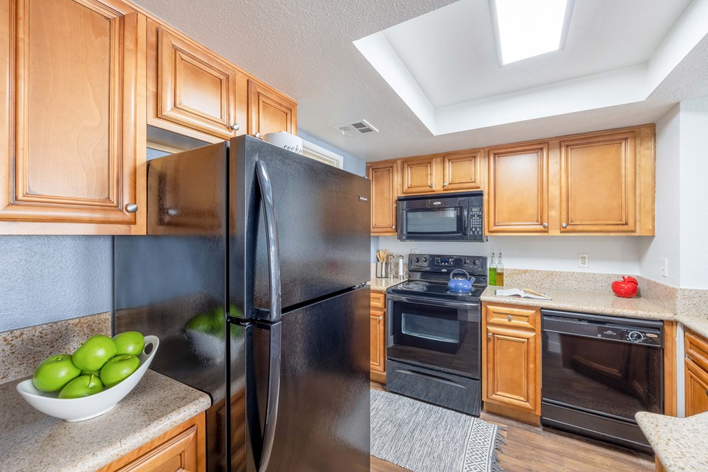 a kitchen with wood cabinets and black appliances