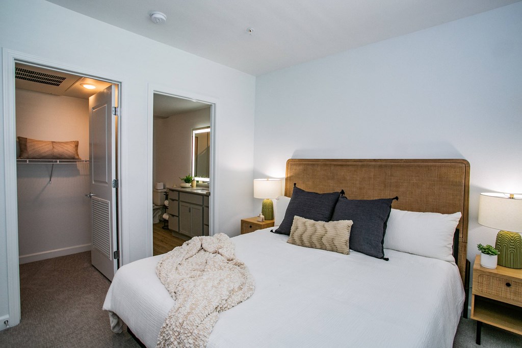 a bedroom with a large bed and a bathroom