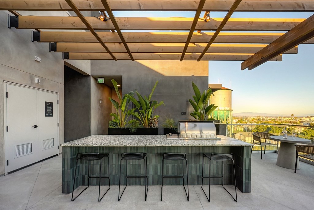 the outdoor kitchen has a bar and a view of the city