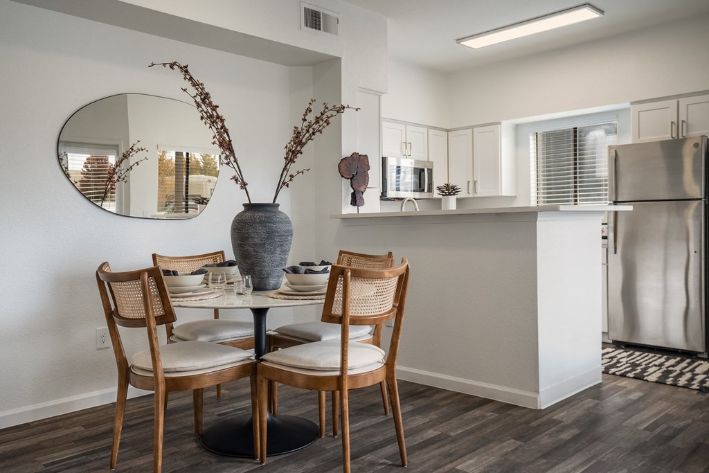 a dining room with a table and chairs and a kitchen with a refrigerator