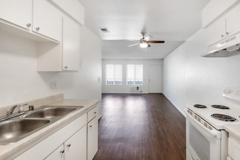 A kitchen with white cabinets and a stove top oven.