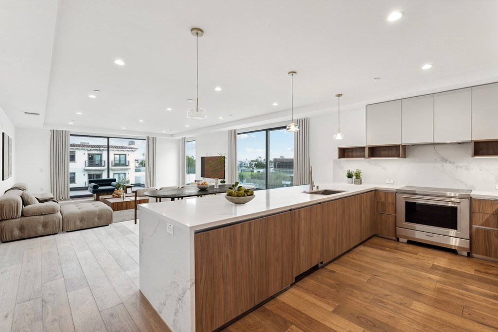 A modern kitchen with wooden cabinets and a marble countertop.