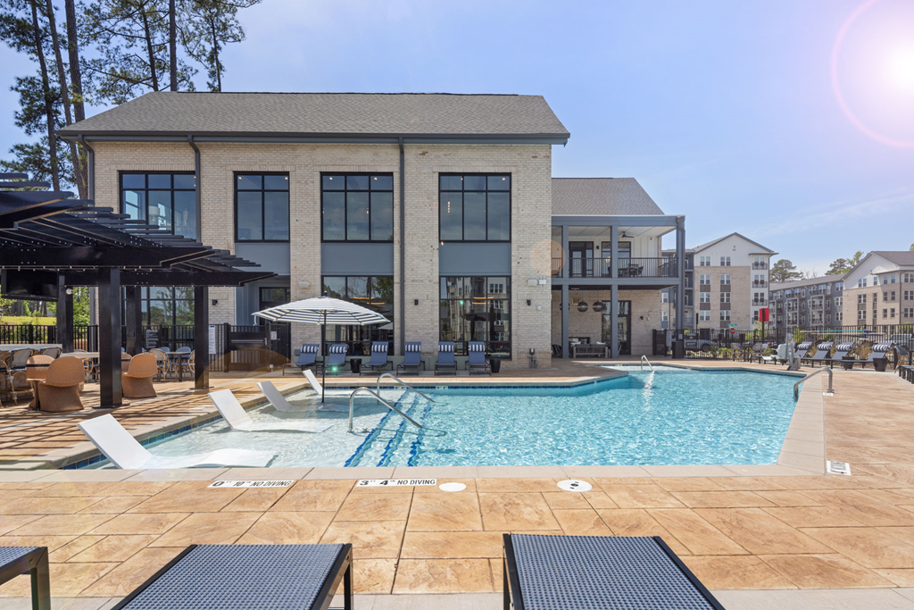 A large building with a pool in front of it.